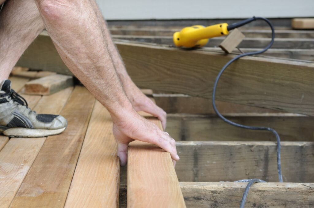 Professional technicians working on damaged wooden boards during a Deck Repair Ajax, ON project.